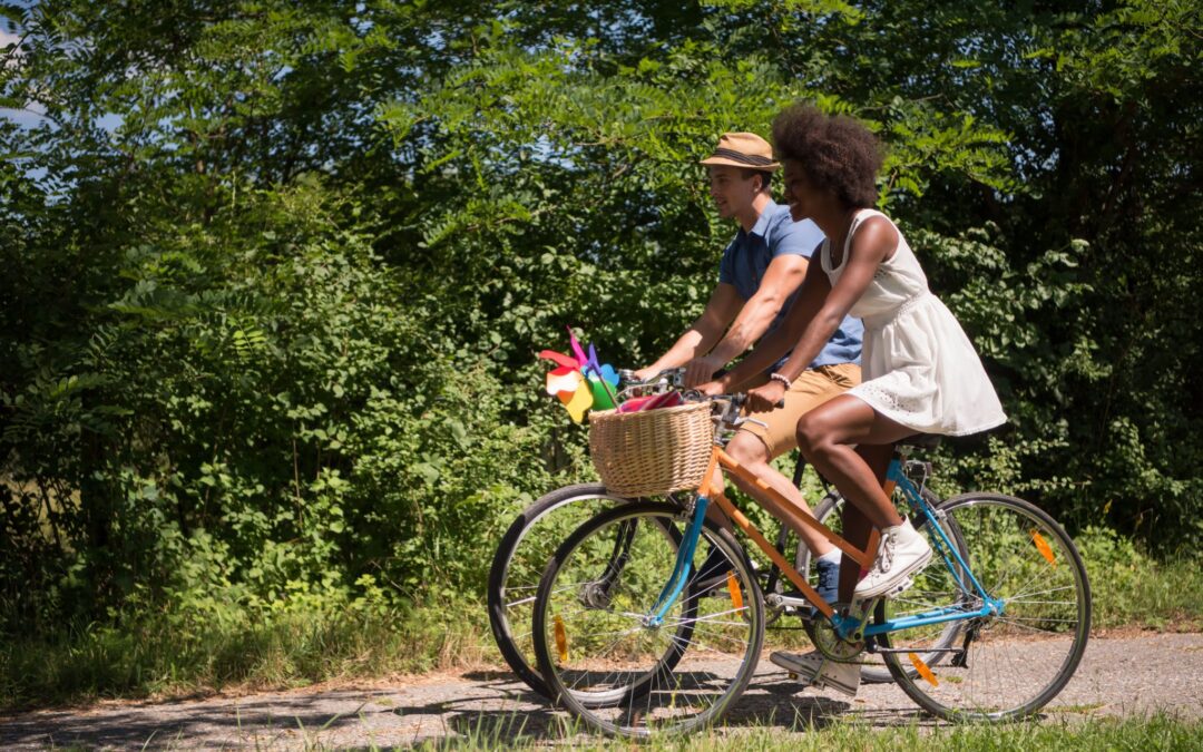 young-multiethnic-couple-having-a-bike-ride-in-nat-PDDKA8W